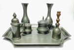 ASCLARTE - Antigo e lindo galheteiro finamente executado em estanho de excelente manufatura nacional, composto por seis peças e uma bandeja. Bandeja mede 31 x 24 cm. Bom estado de conservação. Brasil meados do Século XX.