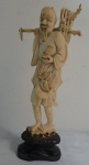 Estatueta de marfim representando Lenhador , acompanha base de madeira . (pequenos quebrados na lenha). Altura 21cm