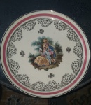 Prato decorativo em porcelana retratando cena galante. Mede 24cm de diâmetro.
