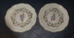 Dois pratos em porcelana com motivos florais.  Mede cada 14cm de diâmetro.