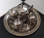 Conjunto de chá ao gosto Luiz XV  com 6 peças constando de 1 bule com 15cm  e 4 xícaras com 9cm de altura com tampa, diferenciada com 2 alças, espessurado a prata, e com bandeja com 25cm de diâmetro.