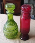 Esplendoroso par de garrafas em vidro moldado padrão rubi e padrão verde, sen do uma cilíndrica e outra bojuda com decorações em losangos. Alt. 23cm