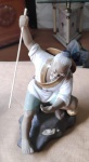Linda escultura oriental, em porcelana, figura de idoso com uma vara na mão direita, se verifica perda do dedão da mão esquerda, Alt. 21cm.