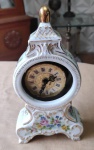 Relógio com caixa de porcelana, não funciona, fundo branco com detalhes em dourado com 19cm de altura