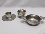 Lote de 3 peças em estanho, composto de 2 petisqueiras e 1 castiçal. Medindo a petisqueira maior com alça 12,5cm de diâmetro x 5cm de altura.