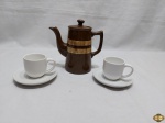 Lote composto de bule e 2 xícaras de café em porcelana, sendo o bule em porcelana inglesa e as xícaras em porcelana branca. Medindo o bule 16cm de altura.