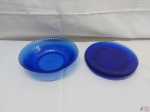 Jogo de travessa redonda funda e 4 pratos rasos em vidro azul moldado. Medindo a travessa 24,5cm de diâmetro x 6,5cm de altura.