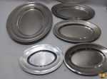 Lote de 5 travessas ovais em aço inox. Medindo a maior 42cm x 30cm. Marcas e modelos diversos. Leves amassados.