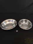 Lote com dois centros de mesa em aço inox, sendo um redondo com bordas vazadas e um oval. Medindo o redondo 22x9cm - oval 27,5x22,5x4,5cm