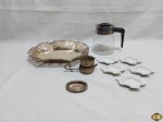 Lote diverso, composto de pãozeira em prata 90, descansos de saquinho de chá em porcelana, etc. Medindo a pãozeira 27cm x 20,5cm x 3,5cm de altura.