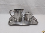 Lote composto de bandeja em aço inox Tramontina, leiteira e açucareiro em aço inox. Medindo a bandeja 34,5cm x 24,5cm.
