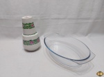 Lote composto de moringa (jarra com copo) em porcelana e travessa oval funda em vidro temperado. Medindo a travessa 31cm x 19cm x 7cm de altura