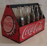 COLECIONISMO- Engradado com a logomarca da Coca Cola, a logo não é pintada . Medindo 32 x 18 x 23 cm.; acompanham dez cascos em vidro de 290 ml.