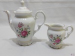 Jogo de bule de café e leiteira em porcelana Schmidt floral com friso ouro. Medindo o bule 18,5cm de altura.