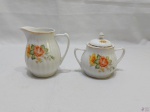 Leiteira e açucareiro em porcelana Pozzani canelada, floral com ouro. Medindo a leiteira 10cm de altura.