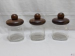 Jogo de 3 potes para condimentos em vidro com tampa em madeira. Medindo 14cm de altura sem a tampa x 9cm de diâmetro de boca