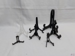 Lote de 7 suportes para prato decorativo, materiais e tamanhos diversos. Medindo o maior 18cm de altura.