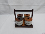 Jogo de 4 potes para tempero em porcelana Schmidt com tampa e suporte em madeira. Medindo os potes 8,5cm de diâmetro x 6,5cm de altura.
