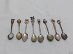 Lote de 8 colheres para colecionador em metal prateado com brasão na pega.