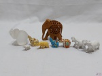Lote 9 enfeites na forma de elefante em materiais diversos. Medindo o maior em madeira 10cm de altura.