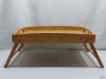 Bandeja retangular em madeira com pés para apiar na cama, etc, da loja Tok Stok. Medindo 50cm x 32,5cm x 24cm de altura aberta.
