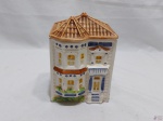 Caixa biscoiteira em porcelana na forma de casa. Medindo 11cm x 9,5cm x 16,5cm de altura. Leve bicado.