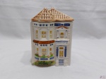 Caixa biscoiteira em porcelana na forma de casa. Medindo 11cm x 9,5cm x 16,5cm de altura. Leve bicado.