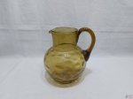 Jarra bojuda em vidro verde moldado. Medindo 22cm de altura x 17cm de diâmetro de bojo.