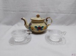Lote de bule em porcelana pintada e 2 xícaras de chá em vidro moldado. Medindo o bule 13,5cm de altura.