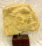 Escultura em pedra                                                                                                              representando,  Rosto assinada, Nicola  datada, 99                                                                        com base de madeira.                                                                                                                                 Alt com base 33 x 30 cm. sem base  25 x 30 cm.  