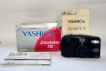 Máquina Fotográfica Yashica Zoomate 70 - Na caixa original + Manual de instruções - Em bom estado de conservação. Porém não foi testado - Medida da máquina: 13 x 7,5 x 4,5 cm.