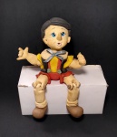Antigo e lindo boneco decorativo Pinóquio - Com pernas articuladas com a posição sentada - Feito em biscuit - Medida: 13 x 14 cm.