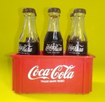 COCA- COLA -  6 mini garrafinhas de vidro da Coca-Cola com logo em versão Russa + mini engradado - Marcou os anos 80. Essa primeira série era incrível. Garrafinhas de vidro com um tipo de caramelo dentro - Medida da garrafinha: 7,8 cm de altura - Medida do engradado: 8 x 5 x 4 cm.
