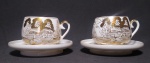 Dois antigos conjuntos de xícara e pires de porcelana casca de ovo, tendo ao fundo imagem de Gueixa. Apresenta pinturas feitas a mão em ouro. Medidas: Pires 10cm diâmetro - xícara - 6cm de diâmetro.