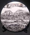 Lindo adorno de mesa ou parede, em espessura porcelana, com paisagem da cidade austríaca de Salzburg. Medida: 16 cm diâmetro. X 1cm espessura. Acompanha suporte.