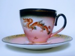 Lindo conjunto de xícara e pires em porcelana oriental , adornada com imagem de dragão, ramos e flores. Medida: pires - 10,50 cm de diâmetro - xícara - 6, cm diâmetro X 5 cm alt.