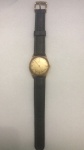 Relógio de pulso de cavalheiro Cyma Cymaflex  1960 com caixa circular em ouro 18 quilates, mostrador dourado assinado com numerais dourados em forma de bastão e segundos centrais, em uma pulseira de couro preto. Não testado.