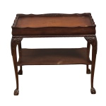 Mesa lateral em madeira nobre  e maciça, com platô inferior, tampo em couro pirogravado, quatro pernas terminas em pés de garra com bola. Laterais trabalhadas em relevo. Século XIX. Retirada na Barra com hora marcada. Medida:  58 alt x 44 larg x 67 comp