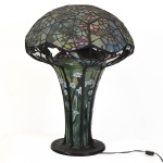 Luminária de mesa padrão Tiffany (mesma fundição) estilo Art Noveau elegantemente executado com 3 (três) luzes, cúpula em pasta de vidro floral multicolorido. Dito padrão Orquídea Cogumelo /Teia de aranha. Retirada na Barra da Tijuca com hora marcada. Medida: - 65 cm altura x 50 cm diâmetro Comprado nos EUA há 20 anos. Em perfeito estado. Obs: a fundição é idêntica a da Tiffany, conhecida como Favrile, e projetado com pedaços de um tipo especial de vidro fundido com óxidos metálicos, no abajur Tiffany este vidro ganha diversas tonalidades, formando um pequeno vitral no abajur. No processo de fabricação do abajur são utilizadas técnicas nas quais são usam-se fitas de cobre soldadas que, junto ao pequeno vitral, formam uma peça de aspecto único.