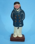 Marinheiro - Escultura em gesso policromado de Marinheiro fardado de sobretudo azul e calça branca. 19 cm. Assinado Letícia 1994 no fundo.