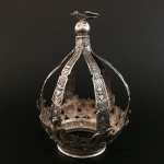 Coroa do Divino executada em prata de lei batida, repuxada e cinzelada. Brasil, Séc. XVIII/XIX. 18 cm de diâmetro.