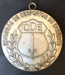 ANTIGA MEDALHA -Comissão de Desporto do Exército CDE. no verso contém a descrição: "Troféu 1ª Brigada INF MTZ - 1º Lugar APE 1975 G TPA". Item em metal - MEDE: 5cm diâmetro. No estado. Possui marcas do tempo.