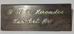 Antiga placa de identificação para mesa em madeira de jacarandá, item apresenta o nome em metal F.A.G .Harcades tenente coronel av. item também serve como peso de papel mede 5,8 cm alt. x 6 cm larg. x 21 cm comp.