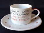 GRACIOSA XÍCARA COM PIRES - EM PORCELANA - personalizada com dizeres "Uso exclusivo de uma pessoa especial" - pires com acabamento interno e borda com corações pintados à mão. Item em bom estado. Medidas: Pires: 2cm profundidade x 14,5cm de diâmetro / Xícara: 6cm altura x 7,5cm de diâmetro x 10cm comprimento (da borda à alça).