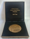 Medalha de Bronze - International Film & Television Festival of New York - 1978. Caixa em madeira forrada. MEDE Medalha: 6,7cm de diâmetro. MOLDURA: 27cm de altura x 3,5cm de largura X 13cm de comprimento.