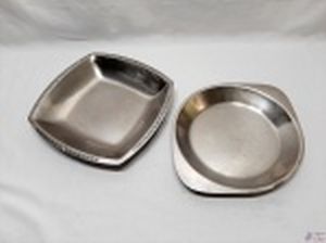 Lote de 2 travessas em aço inox, sendo uma redonda com alça e uma quadrada com borda trabalhada. Medindo a quadrada 29,5cm x 29,5cm x 4cm de altura.