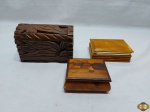 Lote de 2 caixas em madeira e uma em resina, sendo uma em madeira marchetada e uma em madeira entalhada. Medindo a maior 17cm x 10cm x 11cm de altura.