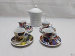 Lote de bule em porcelana branca com 4 xícaras de café em porcelana estampada. Medindo o bule 12,5cm de altura.