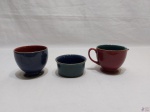 Lote de 2 bowls e 1 cremeira em porcelana colorida. Medindo a cremeira 8,5cm de diâmetro x 7,5cm de altura.