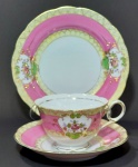 Trio para chá e bolo em porcelana de manufatura japonesa - não é `casca de ovo` - decorada com tons rosa bebê e amarelo bebê e aplicações em ouro. Mede o maior tamanho 18,5 cm de diâmetro.